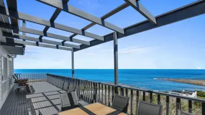 Spacious seafront terrace with pergola and dining—endless views