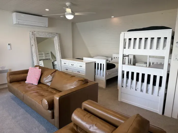 Spacious family room with bunks, single beds, and cozy lounge seating