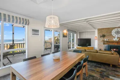 Relax and dine in the open-plan living space, complete with fireplace and ocean views