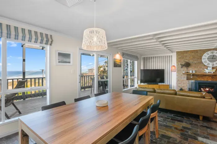 Relax and dine in the open-plan living space, complete with fireplace and ocean views