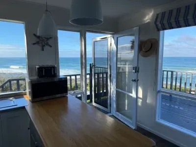 Bright coastal kitchen with private balcony and stunning ocean views