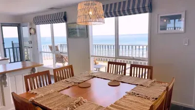 Bright coastal dining with panoramic ocean views and deck access