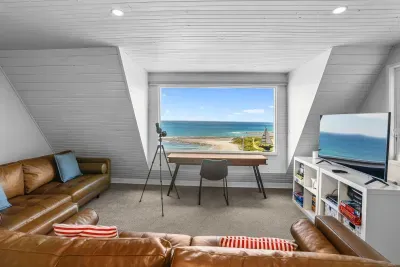 Loft lounge with panoramic ocean views, workspace, TV and comfy leather sofas