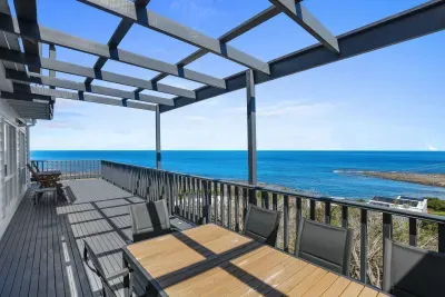 Alfresco dining on the clifftop deck — outdoor table for 6 under the pergola, with the Southern Ocean and Marengo Reef as your backdrop.