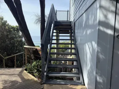 External staircase from carport to deck — approximately 25 steps up to the main entrance, with the Southern Ocean visible at the top. Please factor this in if travelling with heavy luggage or mobility concerns.