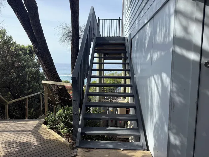 External staircase from carport to deck — approximately 25 steps up to the main entrance, with the Southern Ocean visible at the top. Please factor this in if travelling with heavy luggage or mobility concerns.