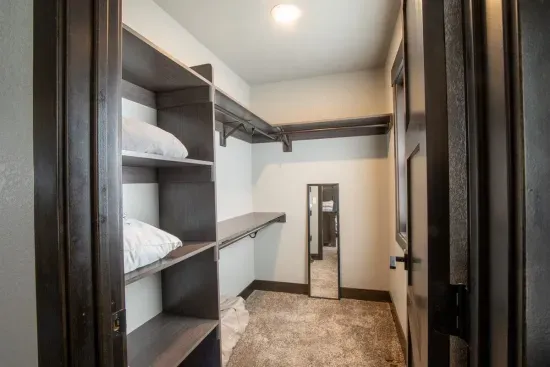 Unpack and settle in—this spacious walk-in closet off the king ensuite makes it easy to stay organized, with plenty of room for your wardrobe and gear.