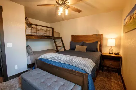A perfect family setup—this spacious main floor room features a cozy queen bed and twin bunks, making it ideal for parents and kiddos to stay close and comfortable.