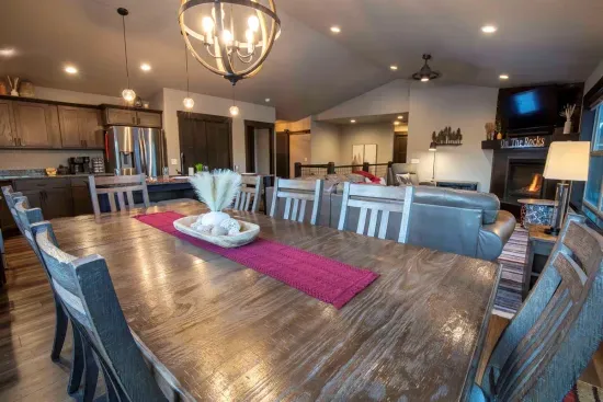 Enjoy a hearty meals at the rustic wooden dining table at "On The Rocks," illuminated by a stylish chandelier. 