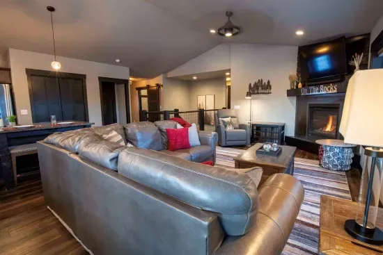 Picture yourself settling into the cozy living area at "On The Rocks," sinking into the plush leather sofa as the fireplace casts a warm glow. 