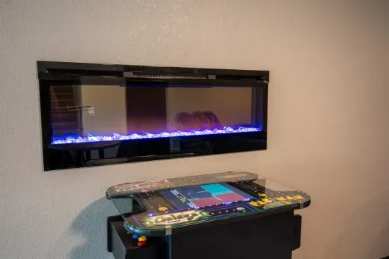 Enjoy the glow of the electric fireplace while you battle it out on the retro arcade—64 classic games and cozy vibes make this spot a guest favorite.