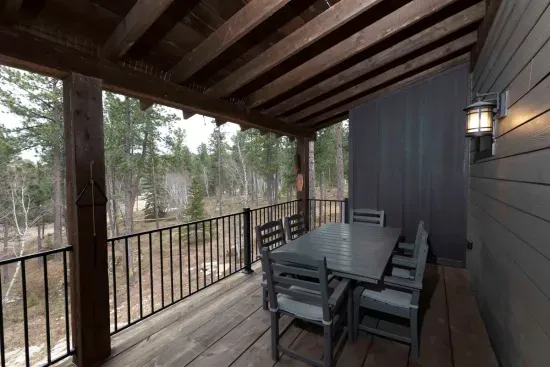 Covered main-level deck with forest views—perfect for morning coffee, outdoor meals, and relaxing in the fresh Black Hills air.