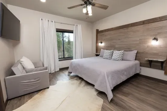 Main-level king suite at Quittin’ Time with a comfortable king bed and quiet forest views. Ideal for guests who want privacy without stairs.
