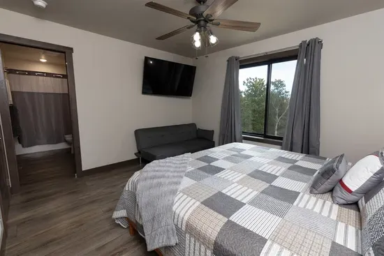 Upper-level king ensuite with a comfortable king bed and peaceful Black Hills forest views. This private bedroom includes its own attached bathroom, creating a quiet retreat upstairs.