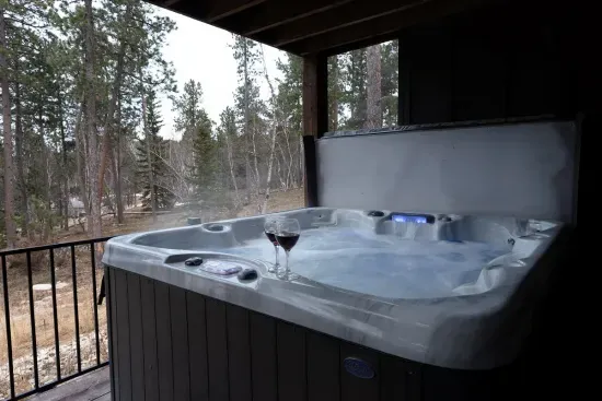 A day of adventure deserves a finish like this—hot tub bubbling, wine in hand, and the quiet pine forest all around.