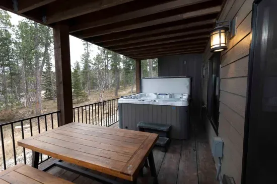 Step outside from the lower-level living room to your private hot tub overlooking the forest—perfect for relaxing after a day on the trails.