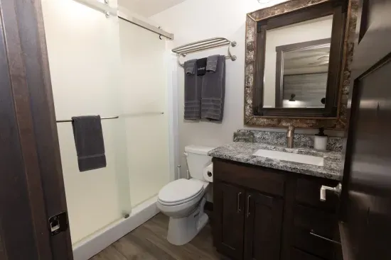 Private lower-level ensuite bathroom with walk-in shower and granite vanity, connected directly to the king bedroom for comfort and convenience.