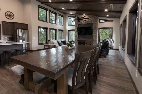 Gather around the large dining table at Quittin’ Time with forest views through towering windows and a stone fireplace nearby. It’s the perfect place for big dinners, morning coffee, and stories after a day exploring the Black Hills.