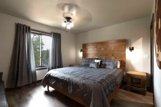 Upper-level king ensuite with a comfortable king bed and peaceful Black Hills forest views. This private bedroom includes its own attached bathroom, creating a quiet retreat upstairs.