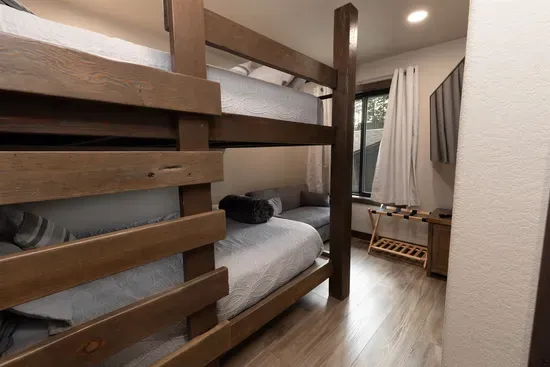 Upper-level bunk room with queen-over-queen bunks and a smart TV—perfect for kids, teens, or extra guests. A cozy space for relaxing after a day exploring the Black Hills.