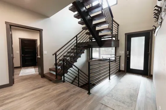 The entryway at Quittin’ Time greets you with modern mountain style and a striking staircase connecting all levels of the home.