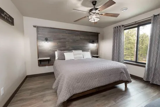 Lower-level king bedroom with forest views and a connecting bathroom that can be accessed from both the bedroom and the lower-level hallway.