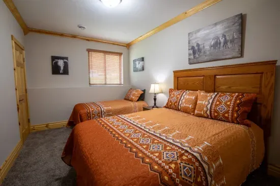 This lower-level room is equipped with a queen and twin bed, providing a comfortable space for rest and relaxation.