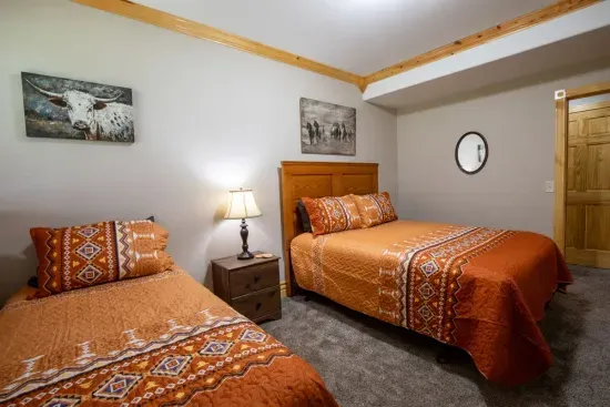 The lower-level room features both a queen and a twin bed, offering flexible sleeping arrangements for your group.