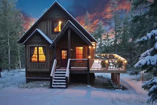 Cozy up inside while the pines glow at sunset—your perfect mountain cabin escape after a day of adventure.