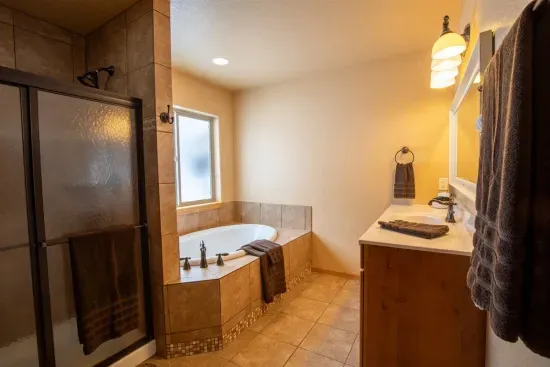 The king ensuite bathroom on the main level features both a walk-in shower and a jetted tub, ensuring you feel relaxed and refreshed during your stay.