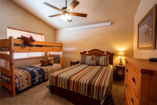 The upstairs queen bedroom boasts XL bunk beds and ample space for all your belongings, ensuring a comfortable and organized stay for everyone.
