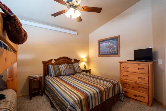The upstairs queen bedroom with bunks promises a restful night’s sleep, helping you recharge for another day of adventure in the Black Hills.