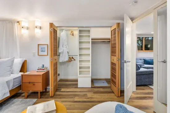 Full closet with fluffy robe, shoe storage, and safe in floor