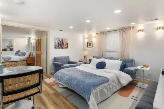 The sofa bed in the living room with privacy blinds, curtains, and dimmable ceiling lights.