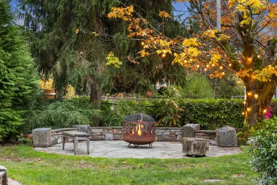 Guests can enjoy this shared space, a blue stone patio with fire pit by the illuminated maple tree.