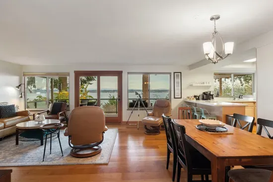 Walls of Windows with views of the water and mountains in open concept room.  Birdwatching or whale watching with Telescope.