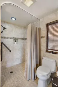 ADA Shower with handrails in the ensuite main bedroom bathroom.  A shower stool is available for use.