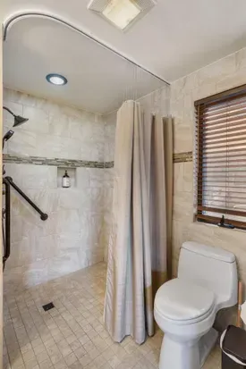 ADA Shower with handrails in the ensuite main bedroom bathroom.  A shower stool is available for use.