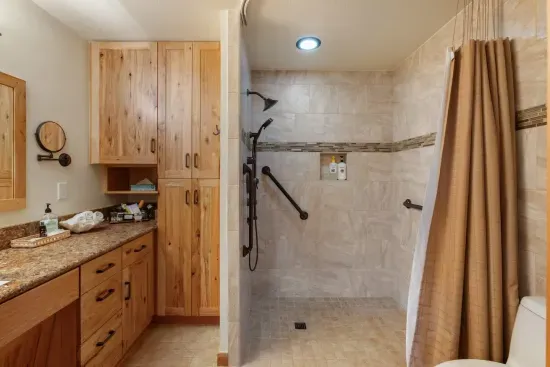 Main Ensuite Bathroom - ADA Compliant Shower with grab bars and handrails and wheel under sink.