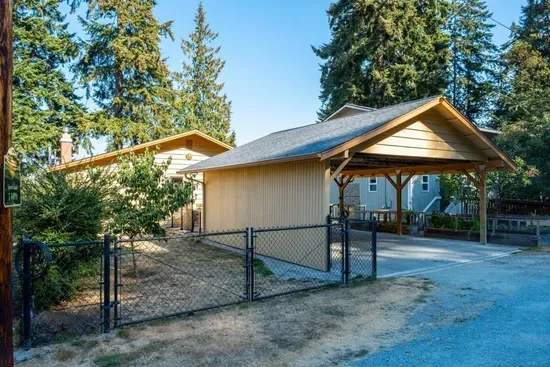 Covered carport is available behind the house.  Parking here is a great option for folks who need to avoid stairs.  The fenced in area includes a grassy back yard perfect for your dog to stretch out.
