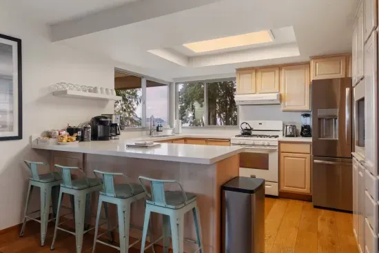 Chef's Kitchen, fully stocked, with coffee station and counter that seats four.  Appliances include toaster, blender, microwave, coffee maker, and tea kettle.