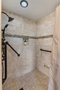The large and spacious and curb-less shower includes handrails and ADA access.