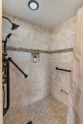 The large and spacious and curb-less shower includes handrails and ADA access.