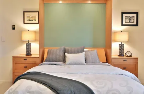 Downstairs, the daylight basement offers a private mini-suite, with a queen bed, dual nightstands and lamps, a TV, a full-size sofa, and a leather chair.