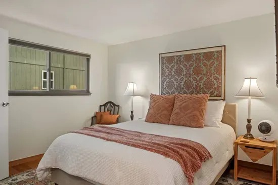 Queen Bedroom on Main Floor with Side Tables and Lamps with block-out blinds, a  hybrid mattress, and a rotating fan.