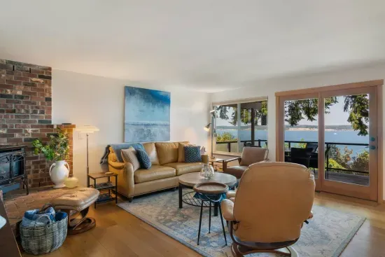 Living room with a wide door and short ramp (ADA)  to an extra large, heated deck with panoramic views of the Saratoga Passage.