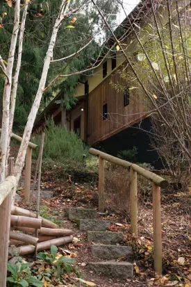 The landscaping at Hillside Haven features charming garden paths and stairways, enhancing the natural beauty of the surroundings.