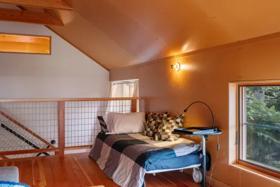 The expansive loft, with its wood-beamed ceilings, features a second day bed and a queen pull out sofa.