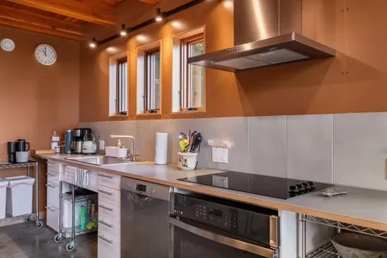 The kitchen is fully stocked with everything you need to prepare an elaborate meal, including a refrigerator, electric stove, oven, dishwasher, and small appliances like a microwave, toaster, and blender.