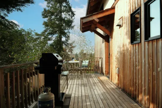 The deck off of the kitchen is expansive, offers water and mountain views, and a gas BBQ.